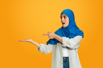 Image showing Portrait of young muslim woman isolated on yellow studio background