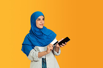 Image showing Portrait of young muslim woman isolated on yellow studio background