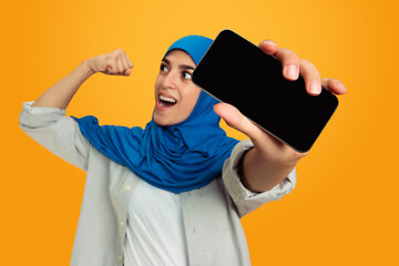 Image showing Portrait of young muslim woman isolated on yellow studio background