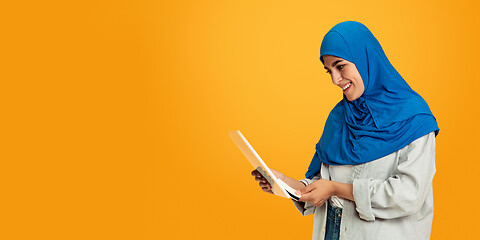 Image showing Portrait of young muslim woman isolated on yellow studio background