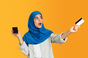 Image showing Portrait of young muslim woman isolated on yellow studio background