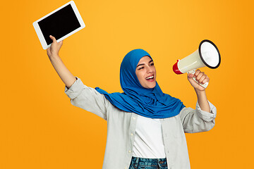 Image showing Portrait of young muslim woman isolated on yellow studio background