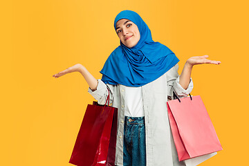 Image showing Portrait of young muslim woman isolated on yellow studio background