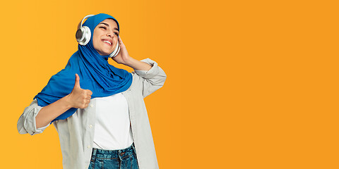 Image showing Portrait of young muslim woman isolated on yellow studio background