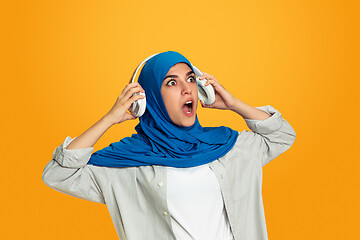 Image showing Portrait of young muslim woman isolated on yellow studio background