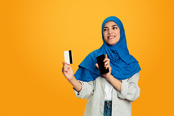 Image showing Portrait of young muslim woman isolated on yellow studio background