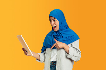 Image showing Portrait of young muslim woman isolated on yellow studio background