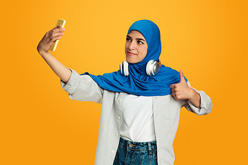 Image showing Portrait of young muslim woman isolated on yellow studio background