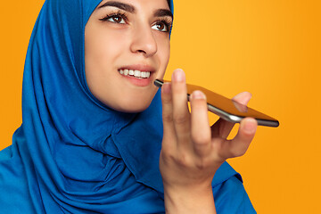 Image showing Portrait of young muslim woman isolated on yellow studio background