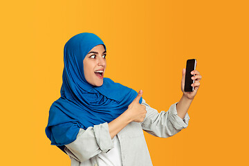 Image showing Portrait of young muslim woman isolated on yellow studio background