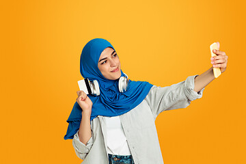 Image showing Portrait of young muslim woman isolated on yellow studio background