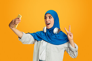 Image showing Portrait of young muslim woman isolated on yellow studio background