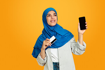 Image showing Portrait of young muslim woman isolated on yellow studio background