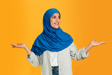 Image showing Portrait of young muslim woman isolated on yellow studio background