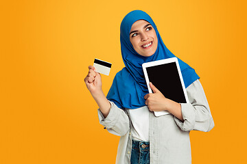 Image showing Portrait of young muslim woman isolated on yellow studio background