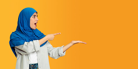 Image showing Portrait of young muslim woman isolated on yellow studio background