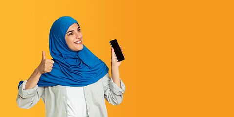 Image showing Portrait of young muslim woman isolated on yellow studio background
