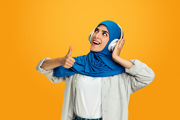 Image showing Portrait of young muslim woman isolated on yellow studio background