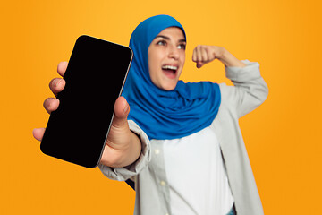 Image showing Portrait of young muslim woman isolated on yellow studio background