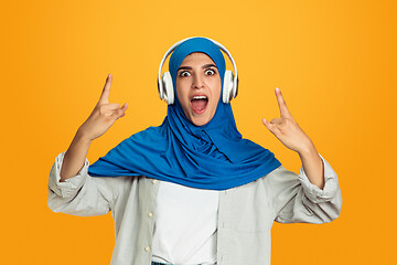 Image showing Portrait of young muslim woman isolated on yellow studio background