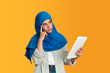 Image showing Portrait of young muslim woman isolated on yellow studio background