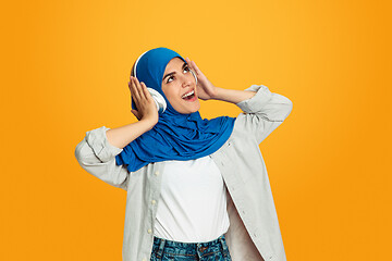 Image showing Portrait of young muslim woman isolated on yellow studio background