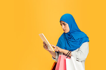 Image showing Portrait of young muslim woman isolated on yellow studio background