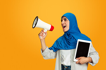 Image showing Portrait of young muslim woman isolated on yellow studio background