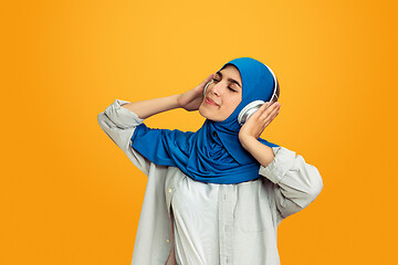 Image showing Portrait of young muslim woman isolated on yellow studio background