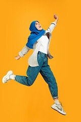 Image showing Portrait of young muslim woman isolated on yellow studio background