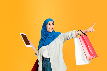 Image showing Portrait of young muslim woman isolated on yellow studio background