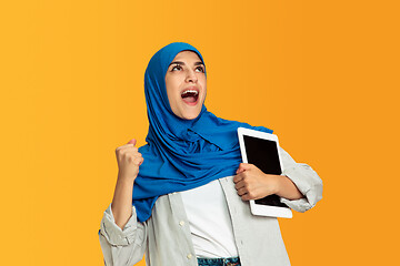 Image showing Portrait of young muslim woman isolated on yellow studio background