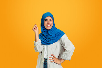 Image showing Portrait of young muslim woman isolated on yellow studio background