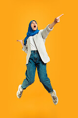 Image showing Portrait of young muslim woman isolated on yellow studio background