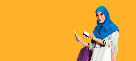 Image showing Portrait of young muslim woman isolated on yellow studio background