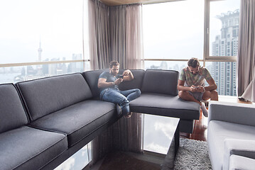 Image showing two young men using a mobile phones  at home