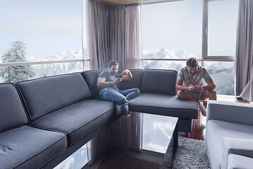 Image showing two young men using a mobile phones  at home