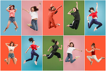 Image showing Freedom in moving. Pretty young woman jumping against orange background