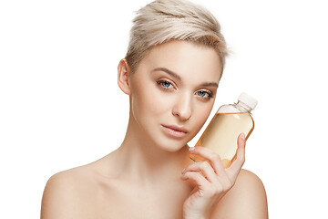 Image showing Beauty concept. The pretty woman with perfect skin holding oil bottle