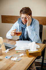 Image showing Sick man while working in office, businessman caught cold, seasonal flu.