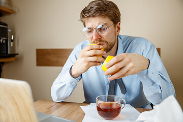 Image showing Sick man while working in office, businessman caught cold, seasonal flu.