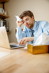 Image showing Sick man while working in office, businessman caught cold, seasonal flu.