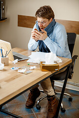 Image showing Sick man while working in office, businessman caught cold, seasonal flu.