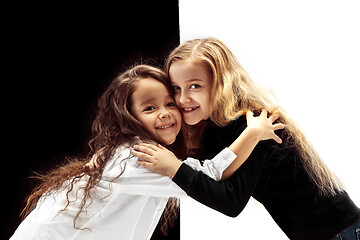 Image showing portrait of two happy girls on a white and black background