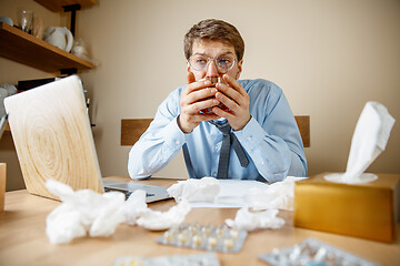 Image showing Sick man while working in office, businessman caught cold, seasonal flu.