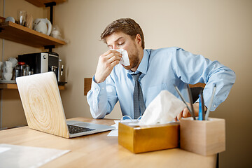 Image showing Sick man while working in office, businessman caught cold, seasonal flu.