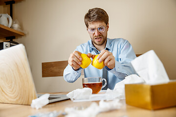 Image showing Sick man while working in office, businessman caught cold, seasonal flu.