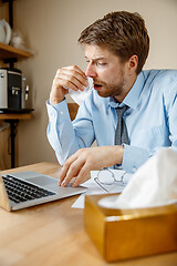 Image showing Sick man while working in office, businessman caught cold, seasonal flu.