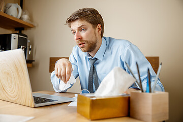 Image showing Sick man while working in office, businessman caught cold, seasonal flu.