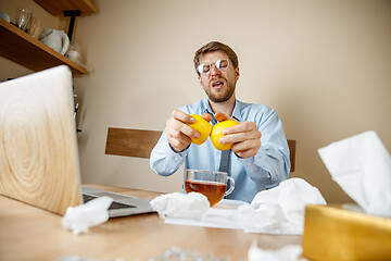 Image showing Sick man while working in office, businessman caught cold, seasonal flu.